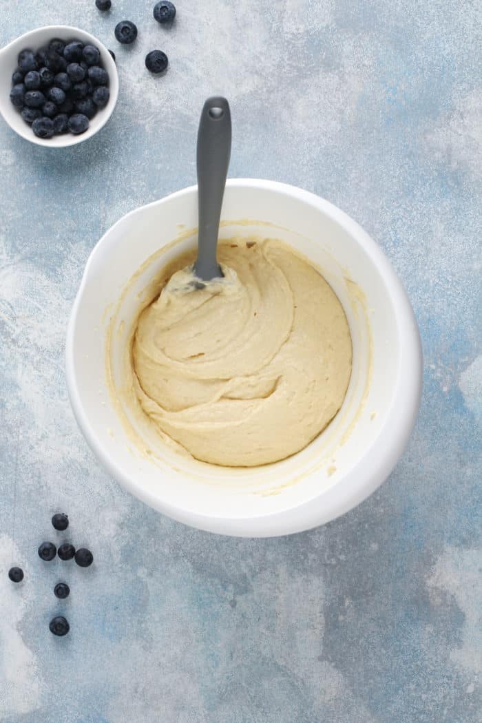 Muffin batter base for blueberry crumb muffins in a white mixing bowl.