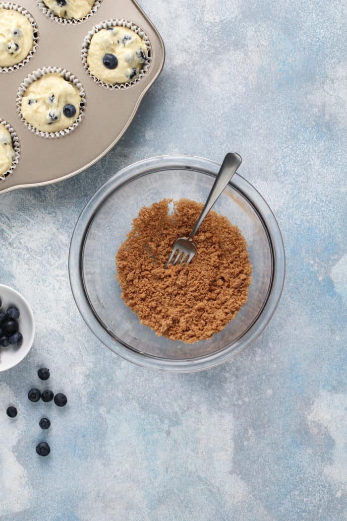 Bowl of crumb topping for blueberry muffins, ready to be sprinkled over the muffin batter.