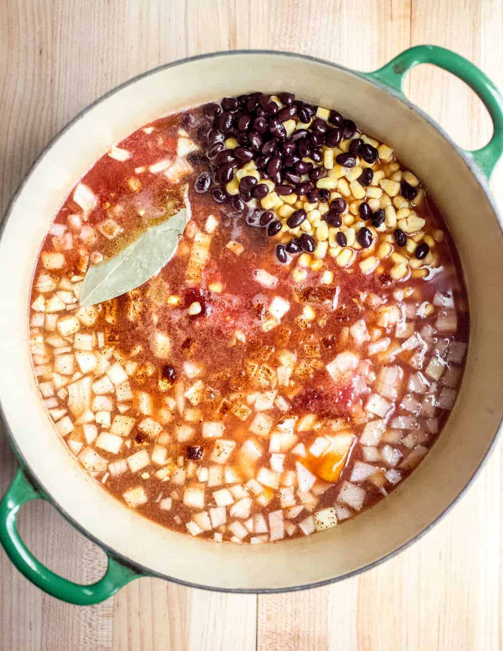 Ingredients for tortilla soup in a Dutch oven, ready to be simmered