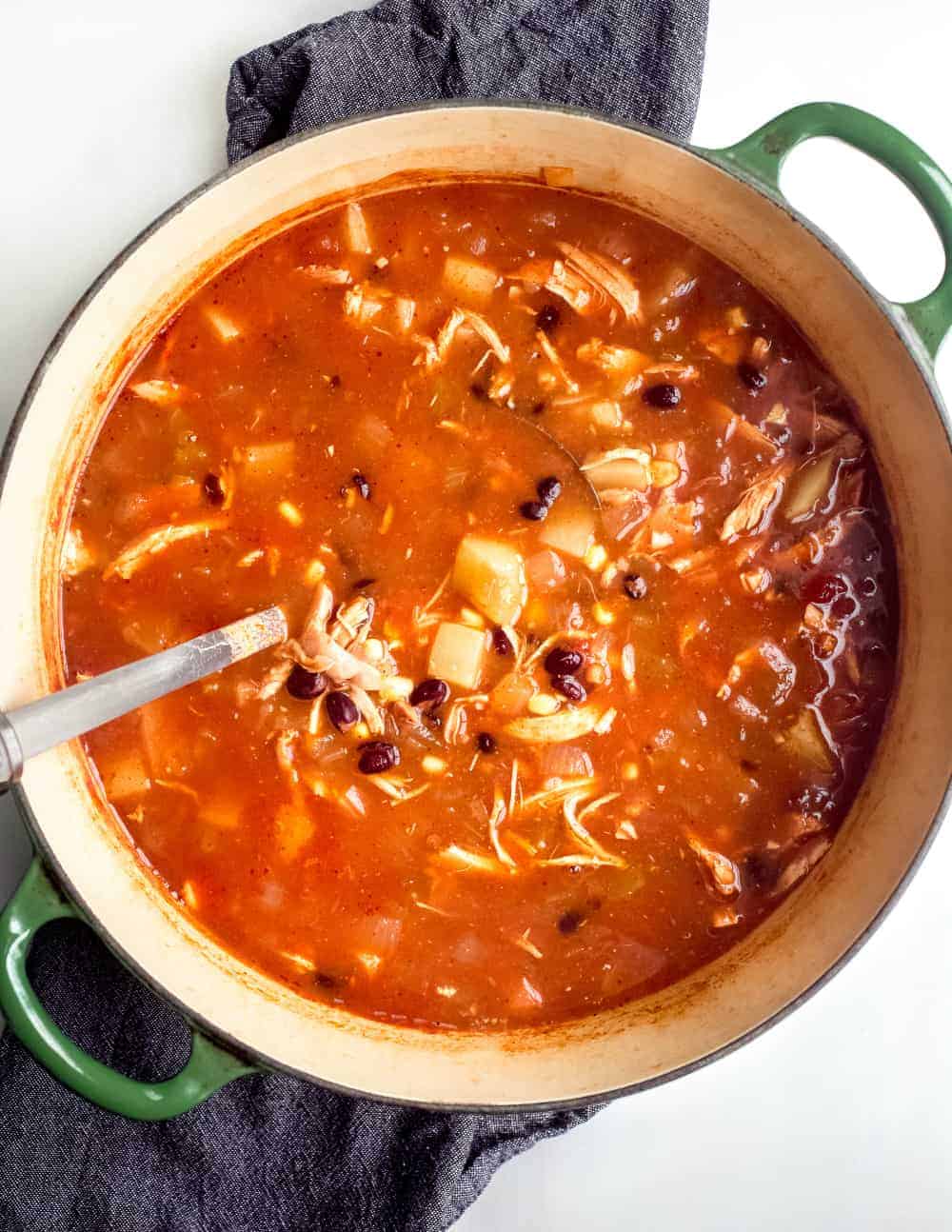 Ladle stirring a pot of tortilla soup