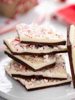Pieces of peppermint bark stacked on a white plate.