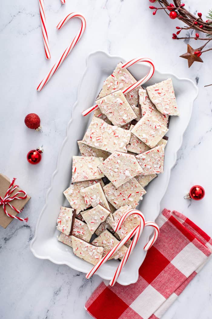 Overhead view of a white platter filled with pieces of peppermint bark.