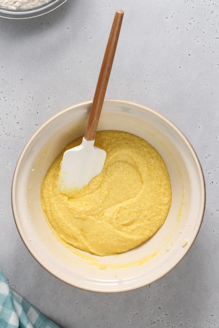 Wet ingredients for sugar cookie bars in a ceramic mixing bowl