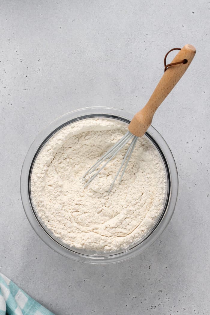 Whisking together the dry ingredients for sugar cookie bars in a glass bowl