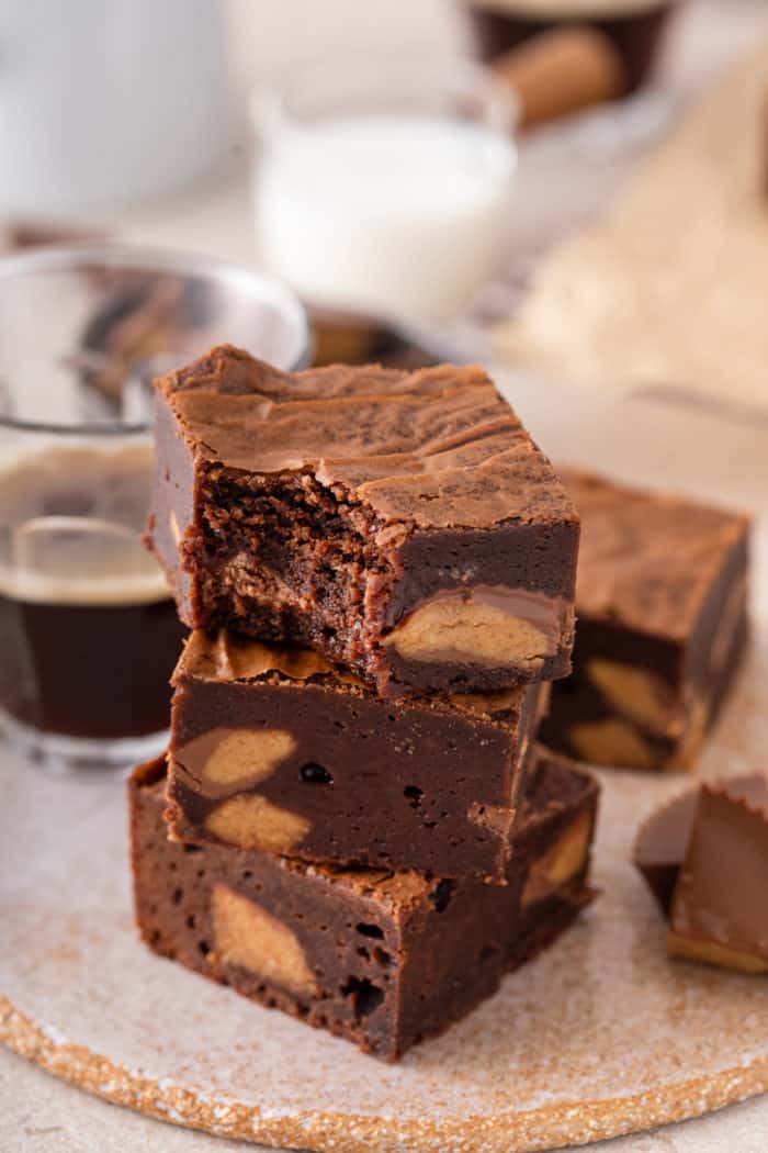 Three stacked peanut butter cup brownies, with a bite taken from the corner of the top brownie.