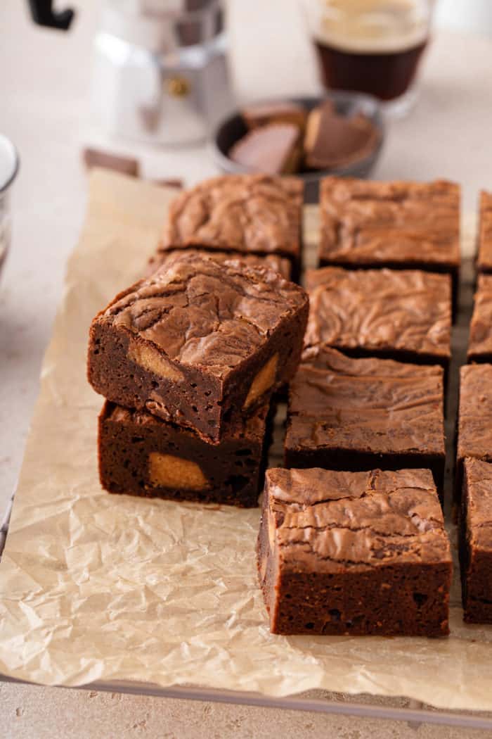 Sliced peanut butter cup brownies arranged on a piece of parchment paper.