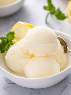 White bowl filled with scoops of lemon sorbet.