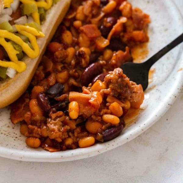 Spoon scooping up old fashioned baked beans from a plate