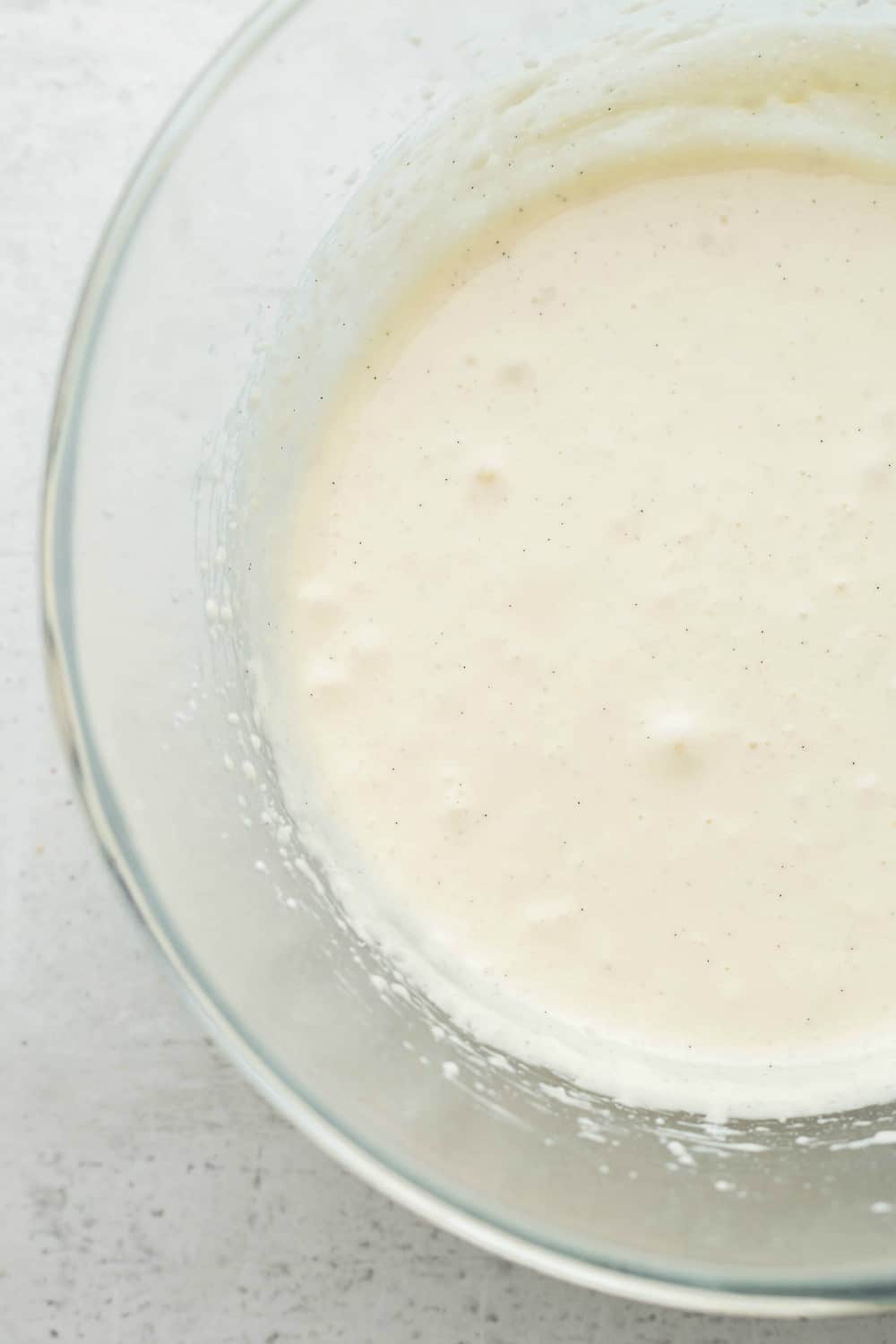 Cream cheese icing for pumpkin cookies in a glass bowl