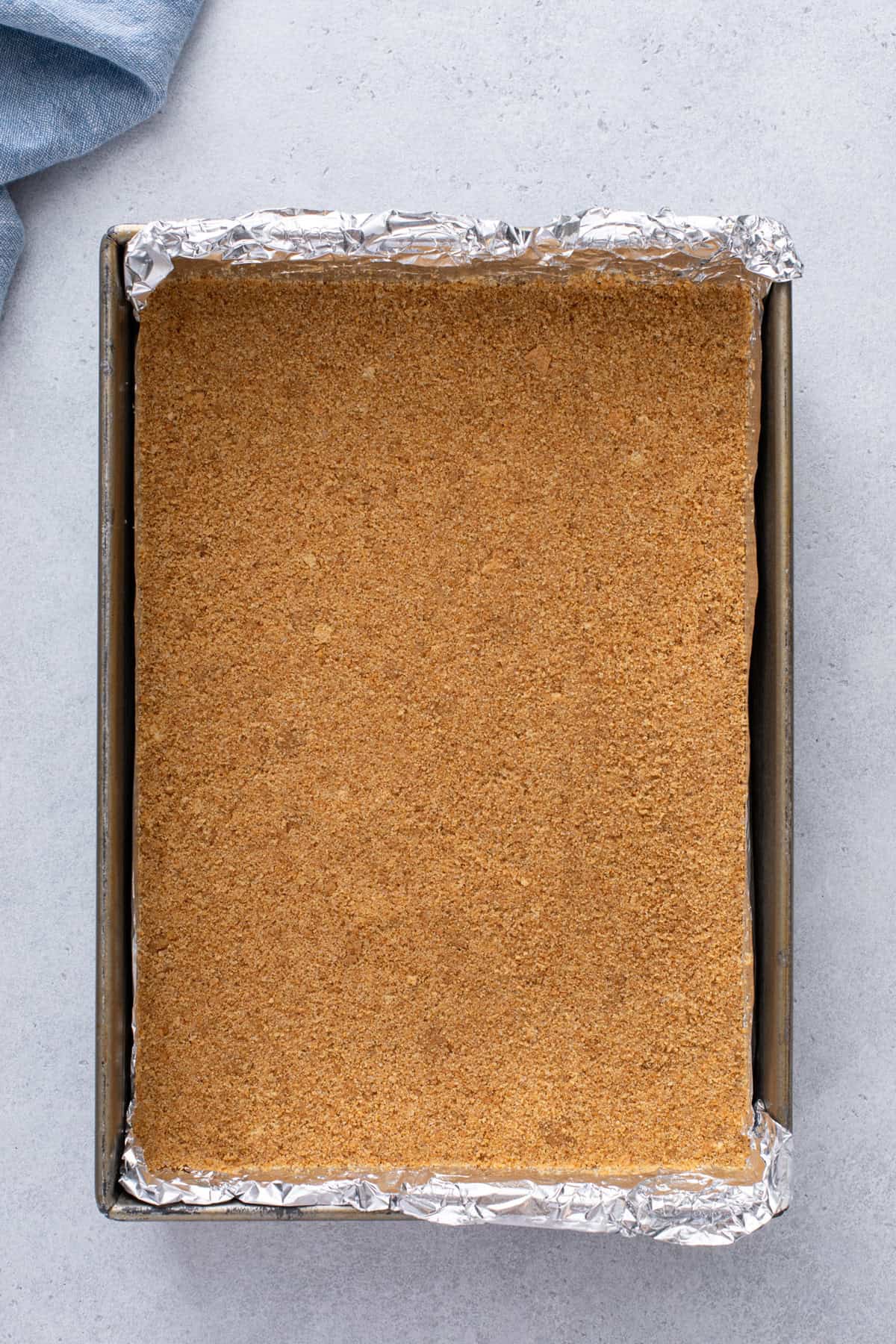 Graham cracker crust pressed into the bottom of a baking pan.