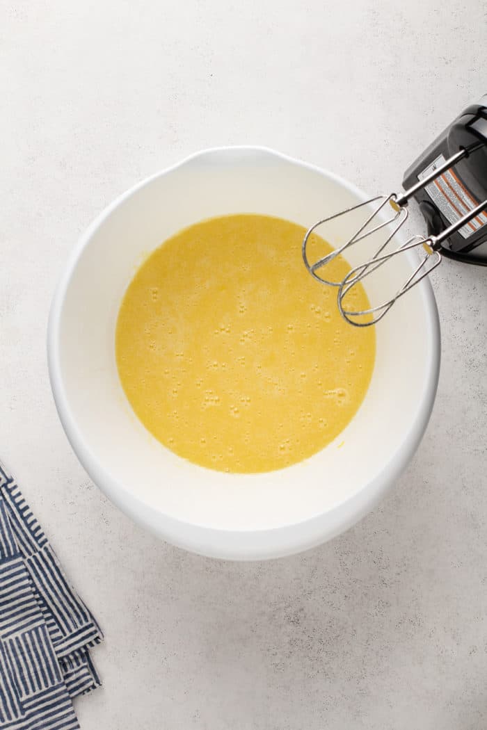 Wet ingredients for carrot cake mixed in a white mixing bowl.