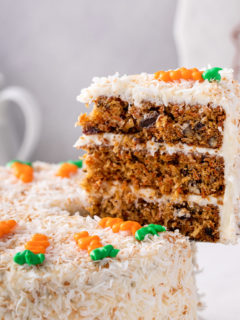 Cake server holding up a slice of 3-layered carrot cake.