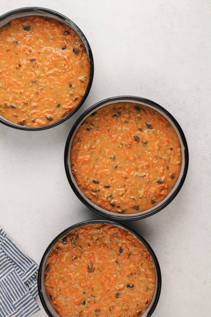 Carrot cake batter in 3 cake pans, ready to go in the oven.