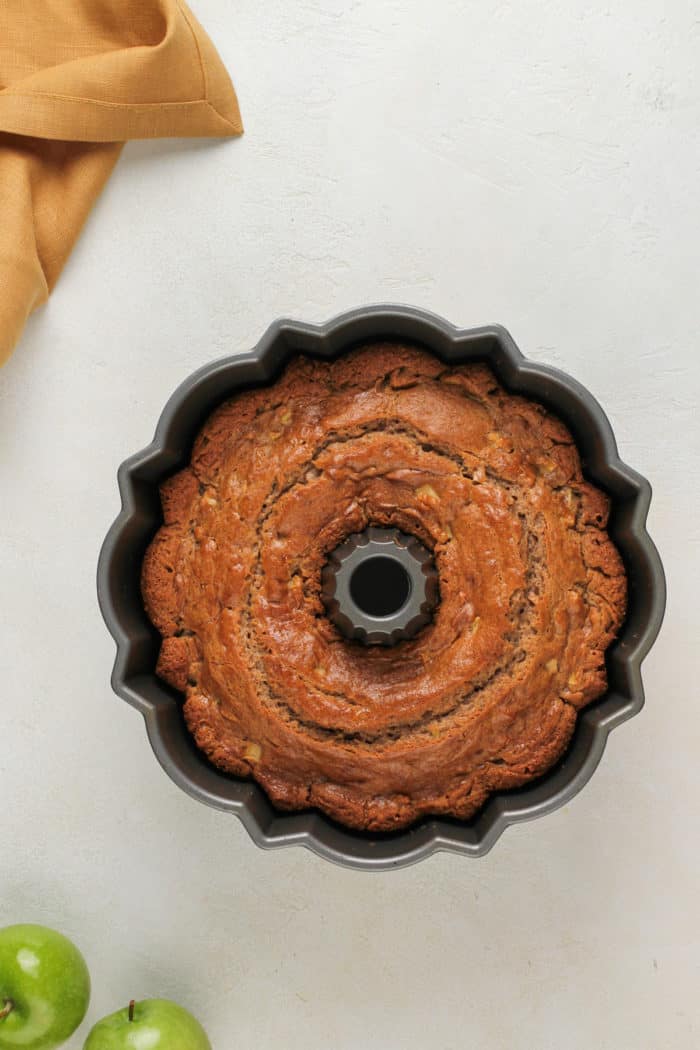 Baked easy apple bundt cake cooling in a bundt pan.