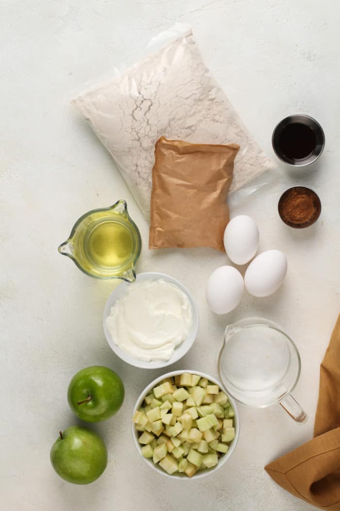 Ingredients for easy apple bundt cake arranged on a light-colored countertop.