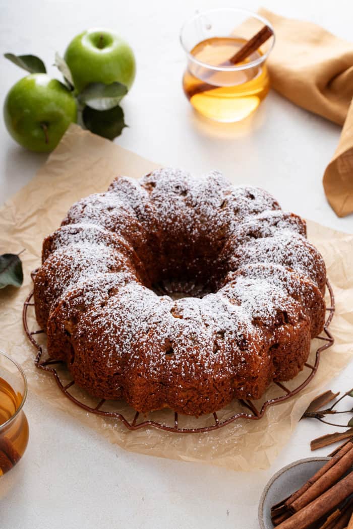 Easy apple bundt cake cooling on a wire rack and dusted with powdered sugar.