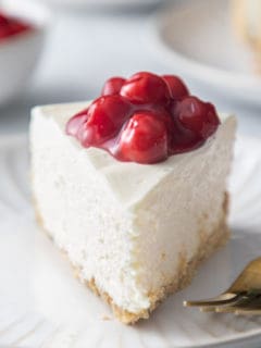 Close up front view of a slice of no-bake cheesecake on a white plate.