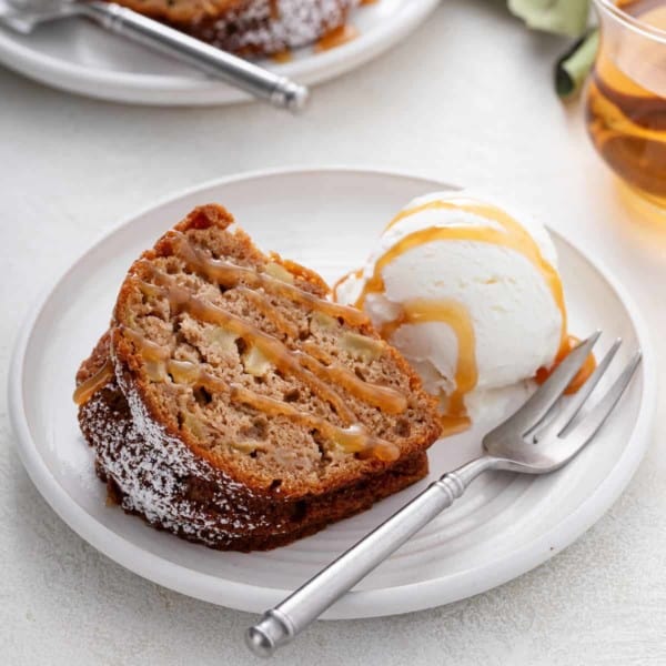 Plated slice of easy apple bundt cake topped with caramel sauce.