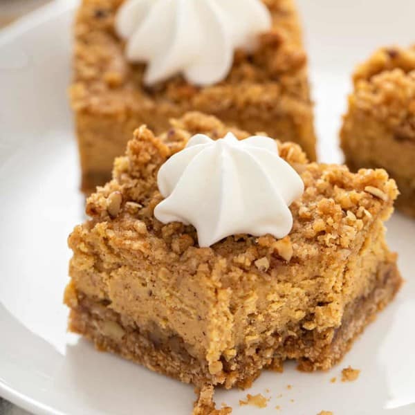 Close up of a pumpkin cheesecake bar with a bite taken out of it