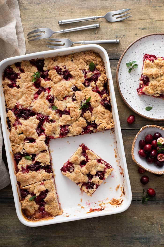 White baking dish filled with sliced cranberry crumb bars