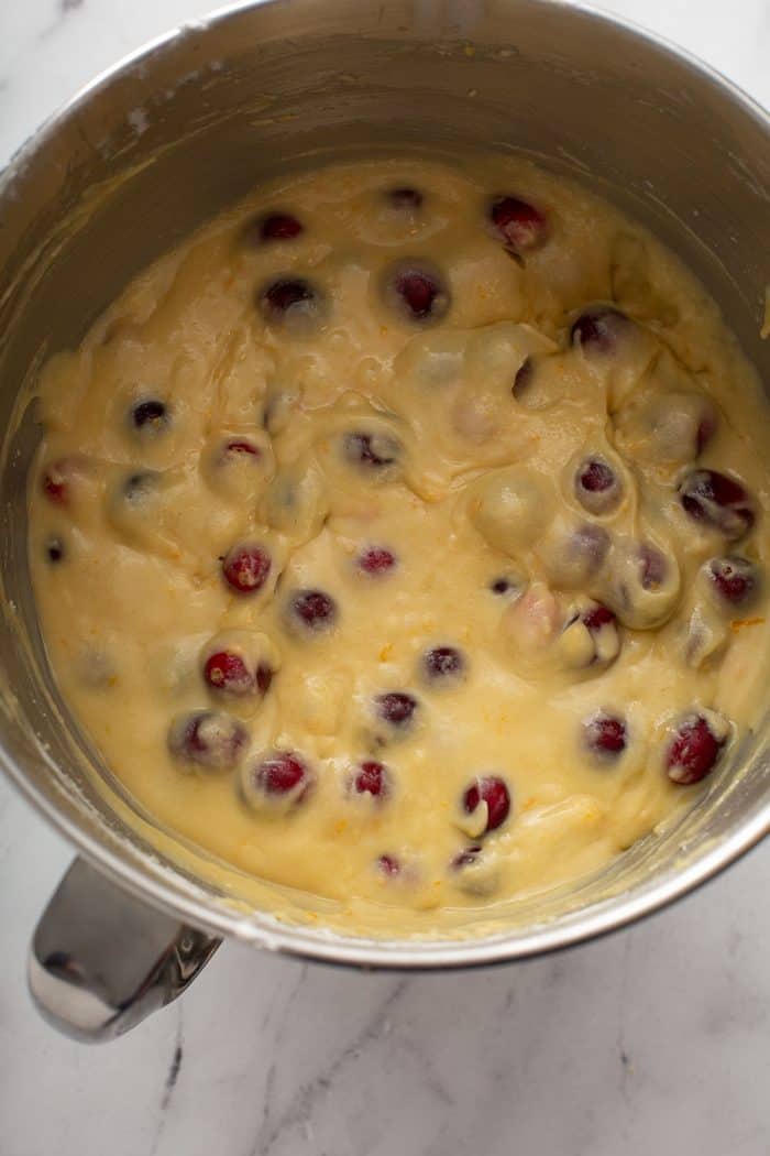 Cranberry orange cake batter in a metal mixing bowl