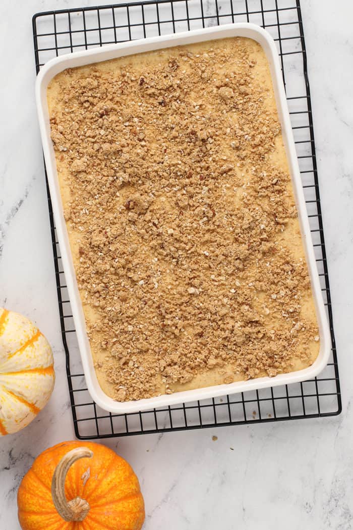 Unbaked pumpkin cheesecake bars in a white baking dish