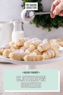 White cake plate piled with clothespin cookies. A hand is dusting powdered sugar over the top of the cookies. Text overlay includes recipe name.