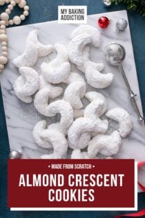 Overhead view of almond crescent cookies on a marble board. Text overlay includes recipe name.