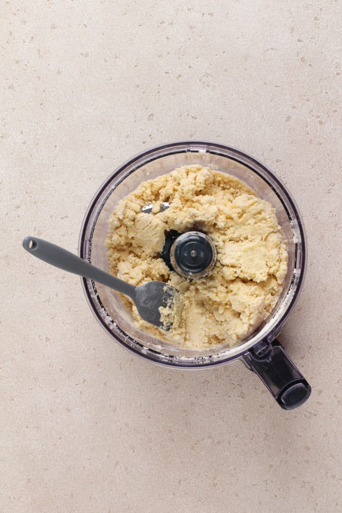 Dough for clothespin cookies in the bowl of a food processor.