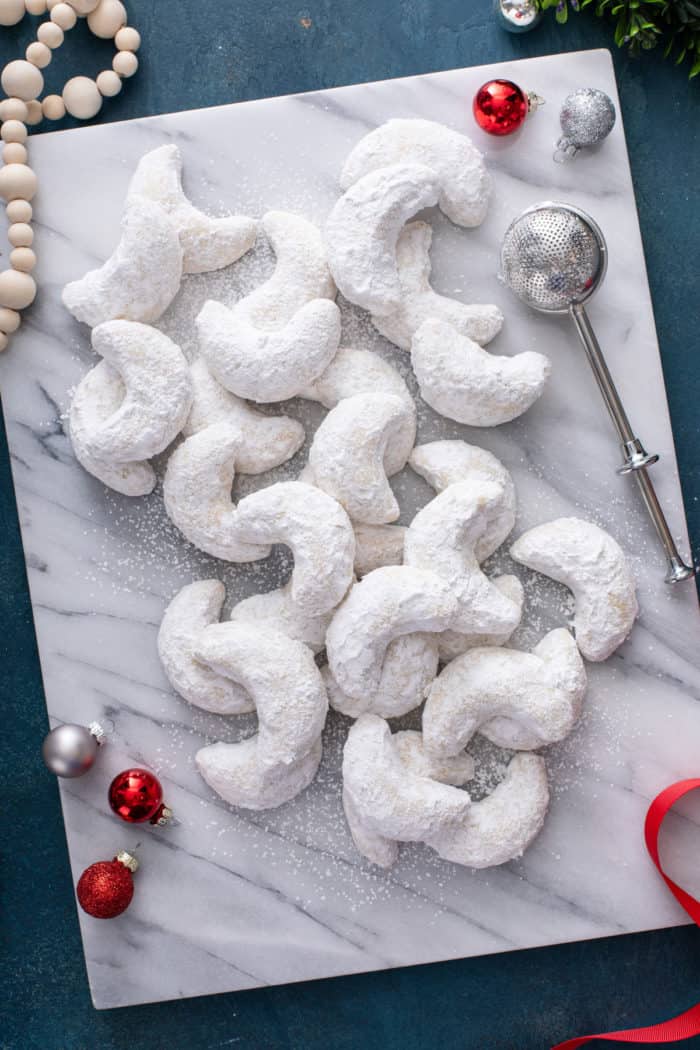 Overhead view of almond crescent cookies on a marble board.