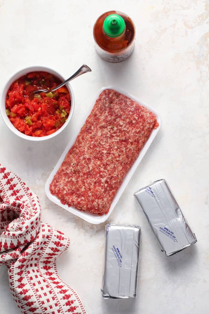 Ingredients for spicy sausage dip arranged on a marble countertop