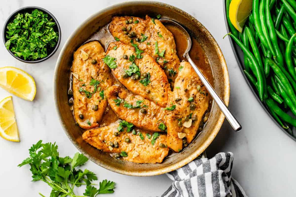 Chicken Piccata is served in a bright lemon-caper sauce and sprinkled with parsley to round out the dish.