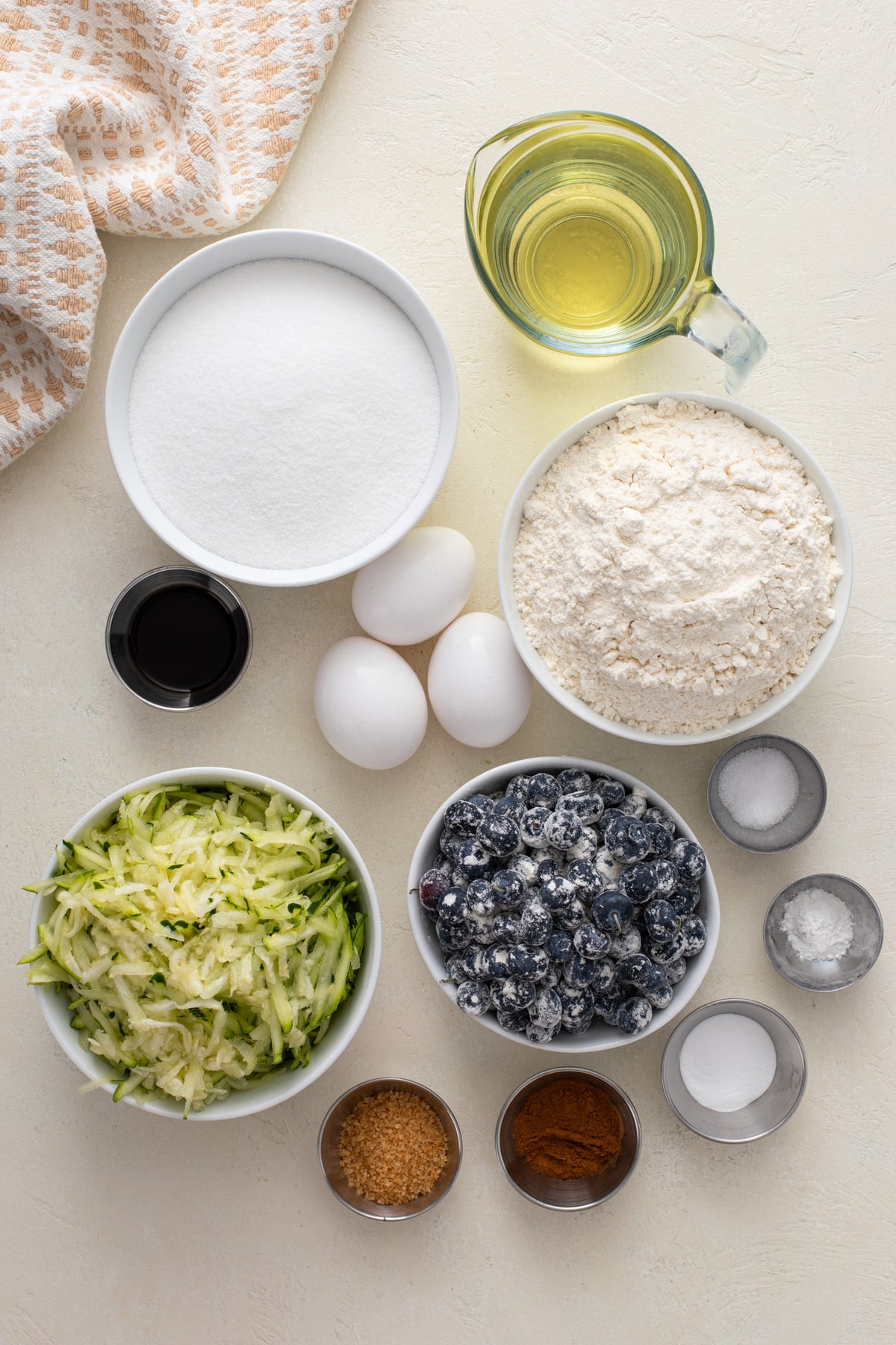 Ingredients for blueberry zucchini bread arranged on a countertop.