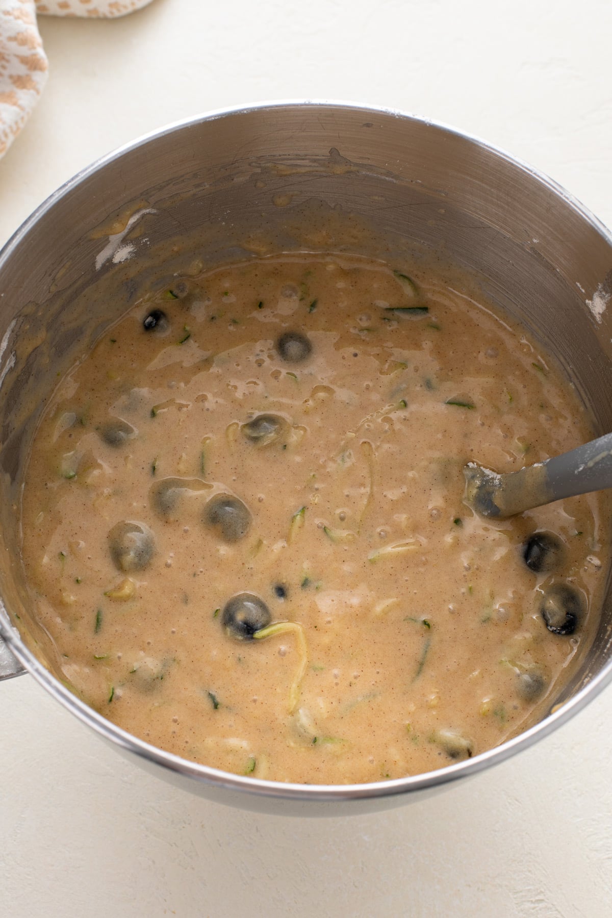 Blueberry zucchini bread batter mixed in a mixing bowl.