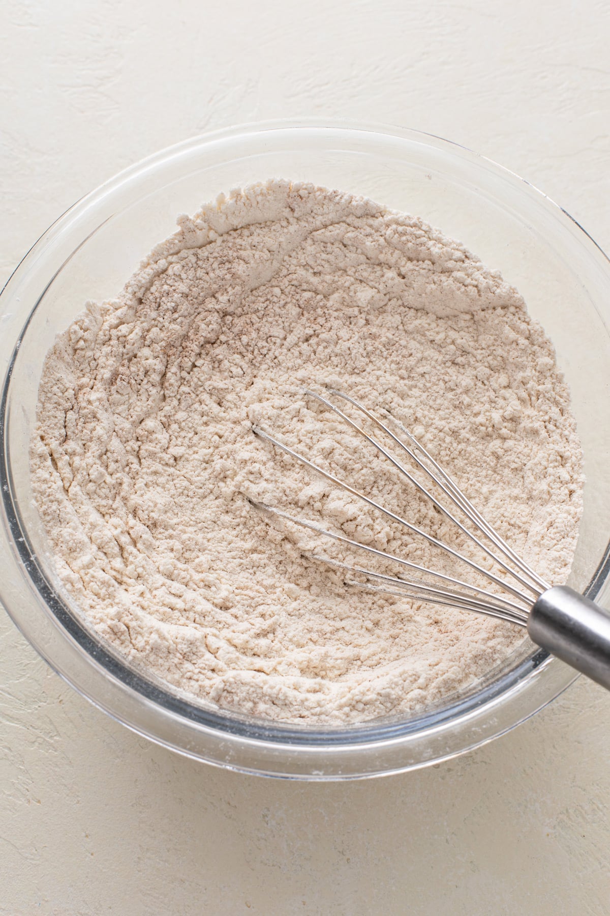 Dry ingredients for blueberry zucchini bread mixed in a glass bowl.