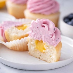 Halved lemon cupcake with blueberry lemon frosting.