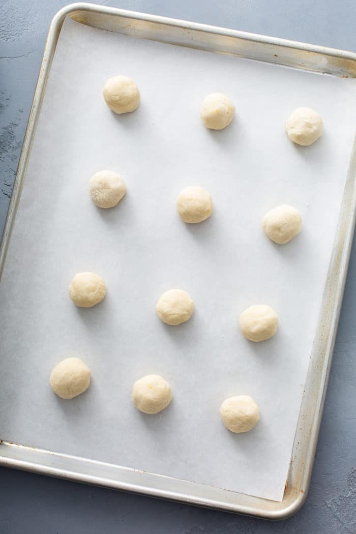 Chewy lemon sugar cookie dough balls on a baking sheet, ready to bake