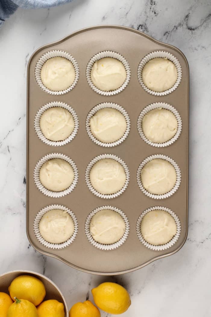 Unbaked lemon cupcakes in a cupcake pan, ready to go in the oven.