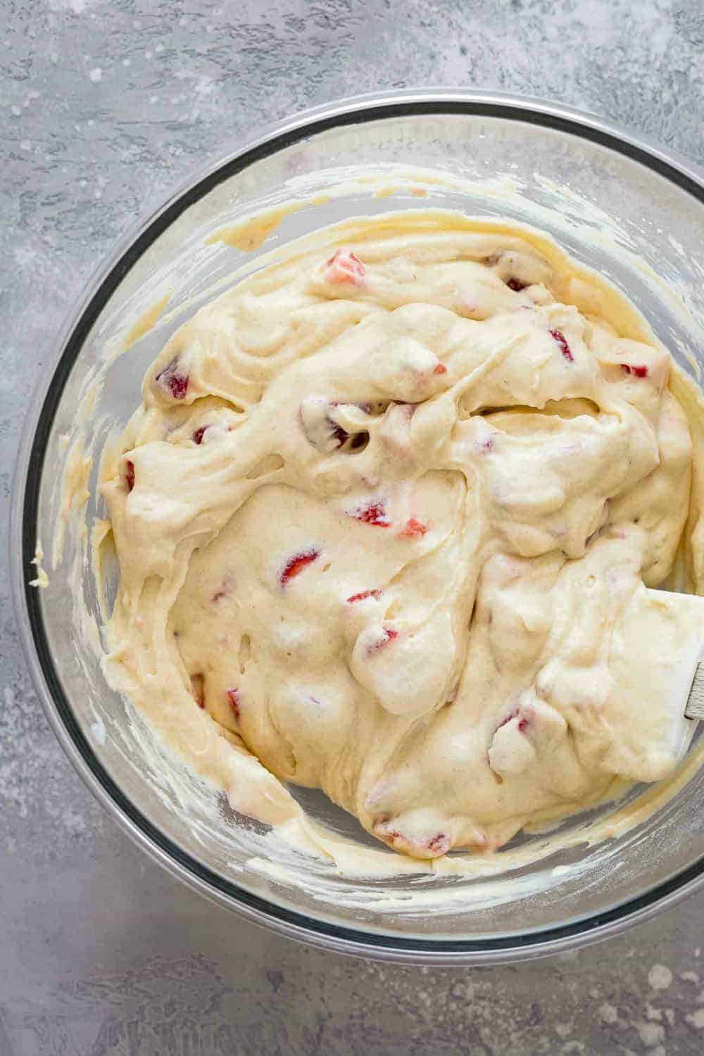 Folding fresh strawberries into quick bread batter with a spatula