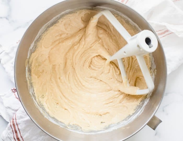 Batter for glazed donut muffins in a metal mixing bowl with the paddle attachment in the bowl