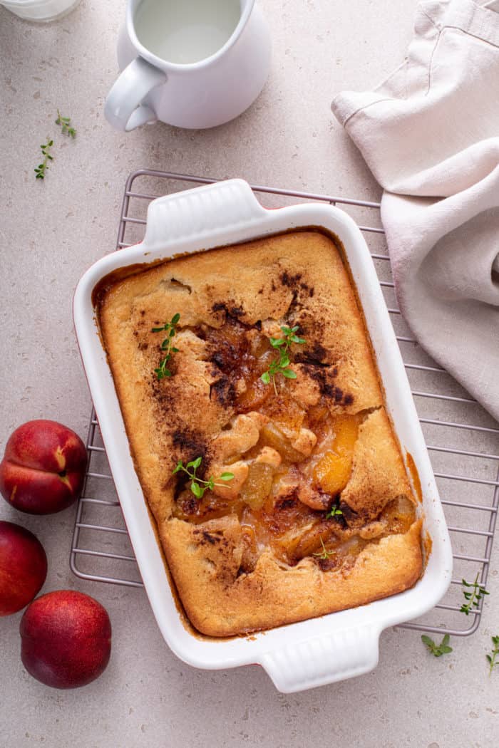 Overhead view of baked homemade peach cobbler on a wire rack.