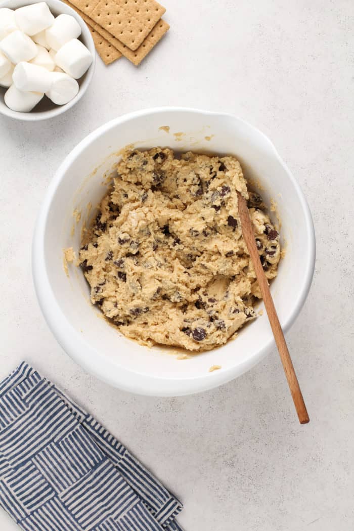 chocolate chip cookie dough for giant s'mores cookies in a white mixing bowl.