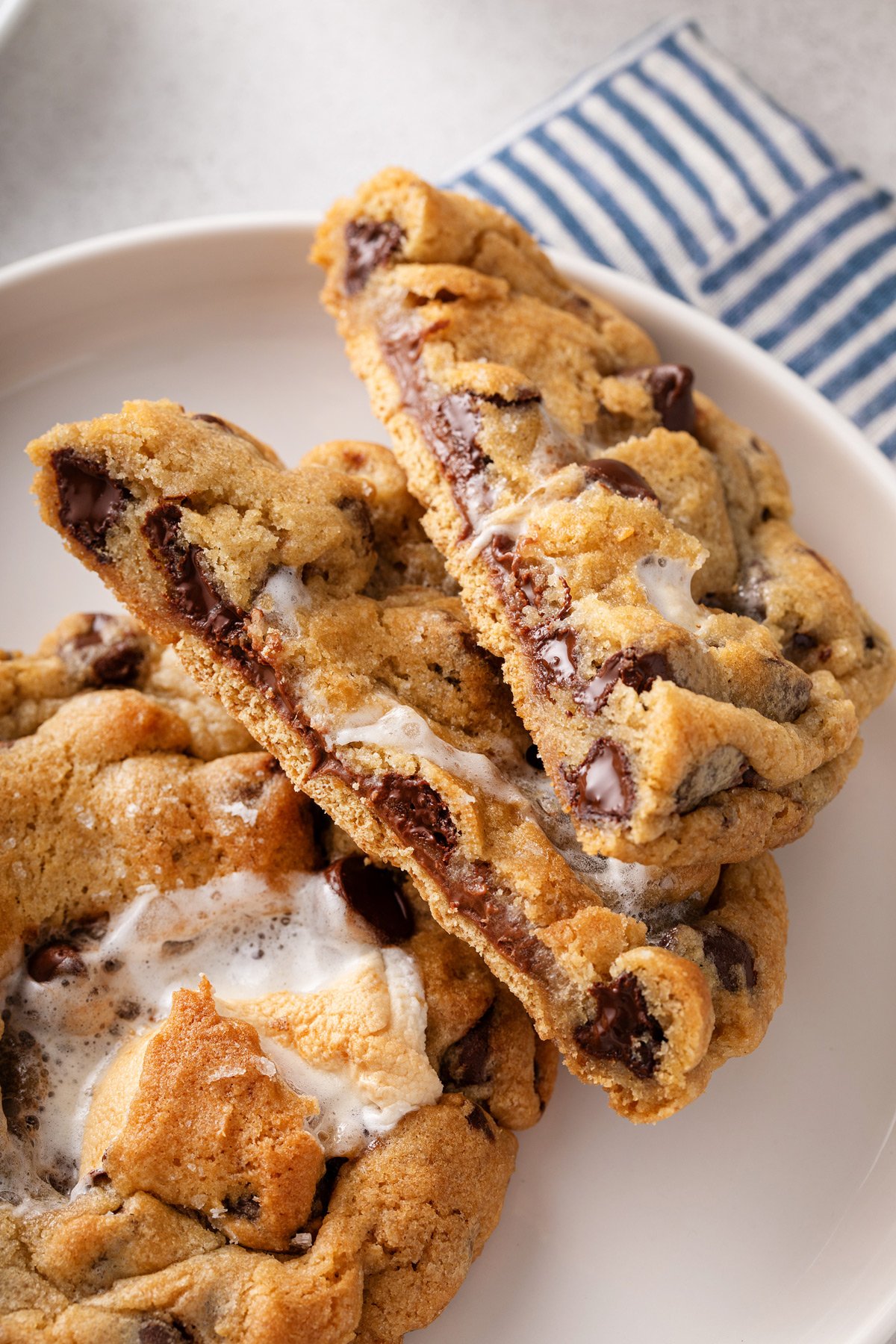 Giant s'mores cookie cut in half to show the graham cracker base and chocolate and marshmallow in the center.