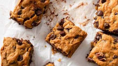 Sliced pumpkin blondies with chocolate chips on parchment paper