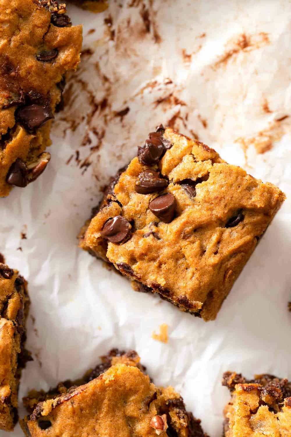 Overhead close up of a sliced pumpkin blondie on parchment paper