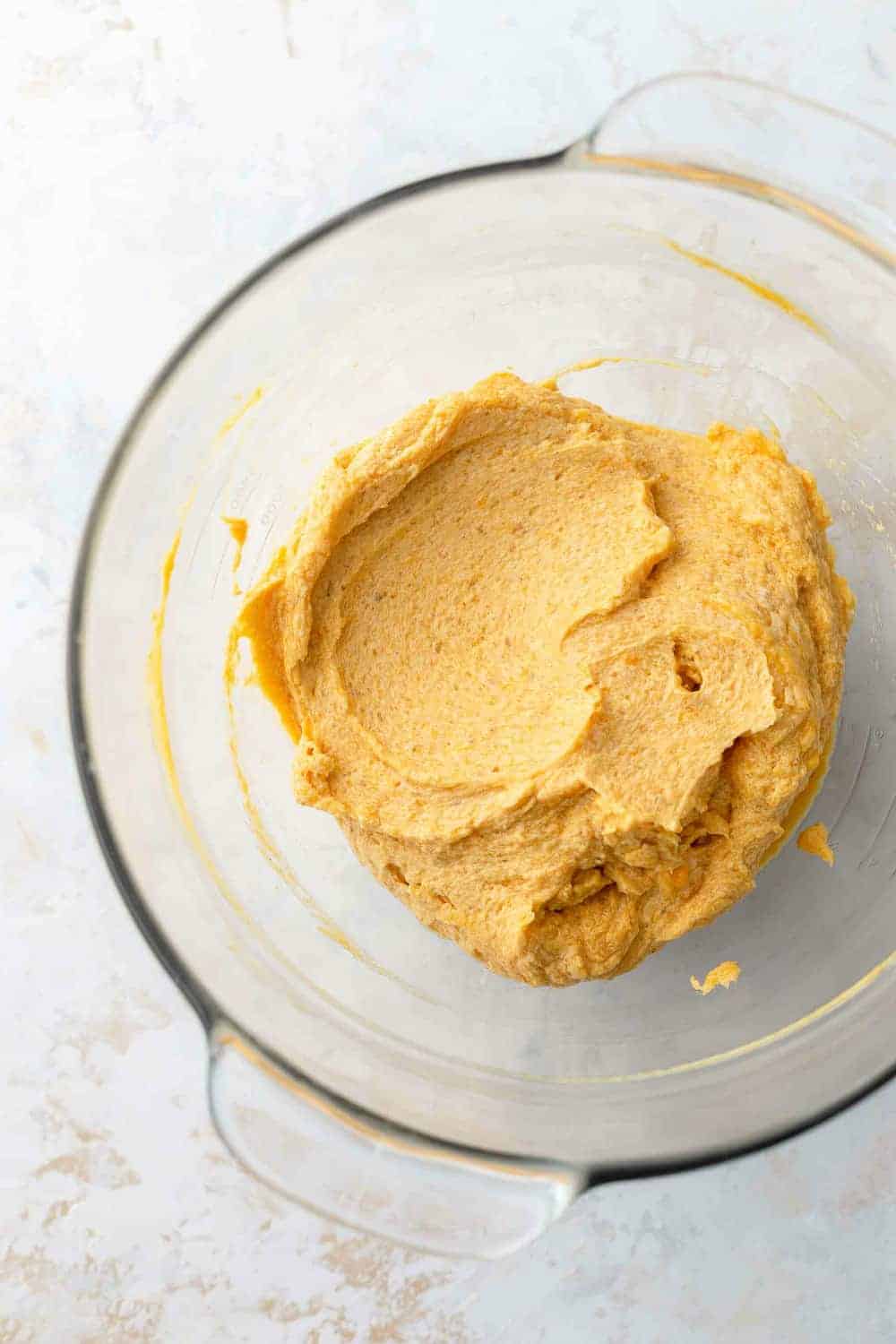 Pumpkin blondie batter in a glass mixing bowl