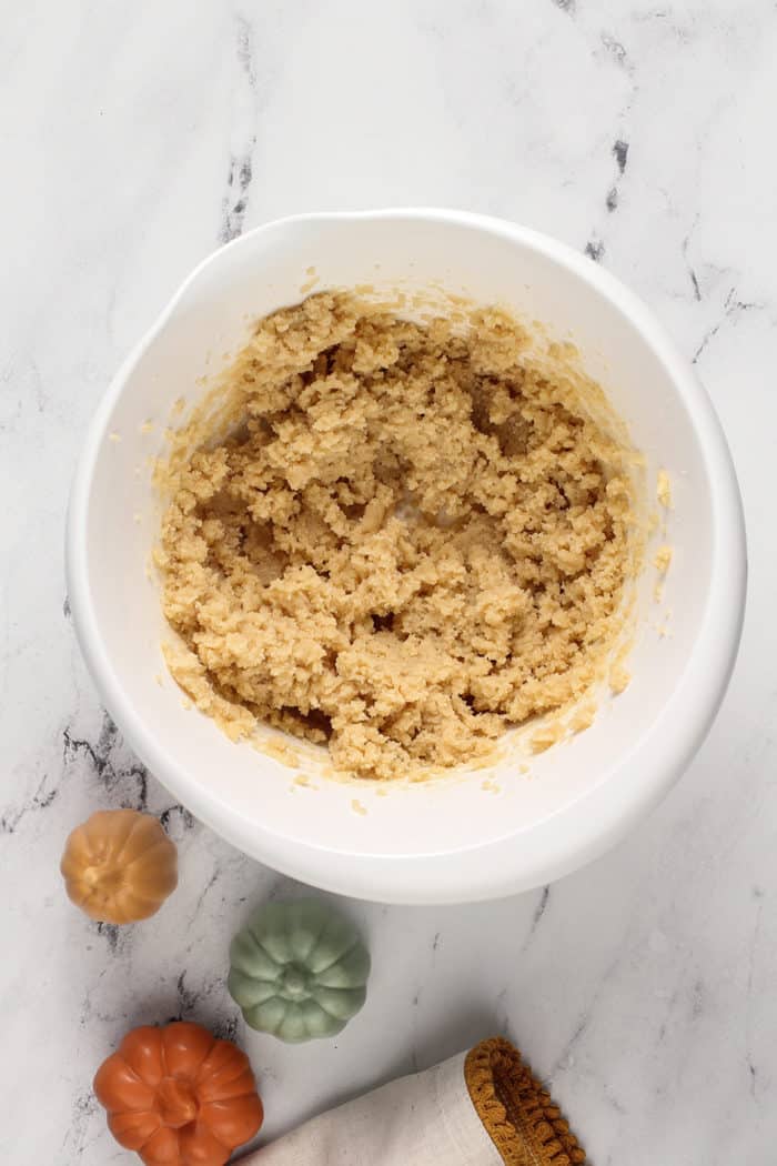 Butter and sugar for pumpkin oatmeal cookies creamed together in a white bowl