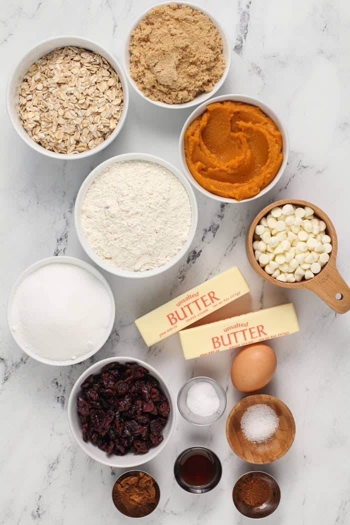 Ingredients for pumpkin oatmeal cookies arranged on a marble countertop