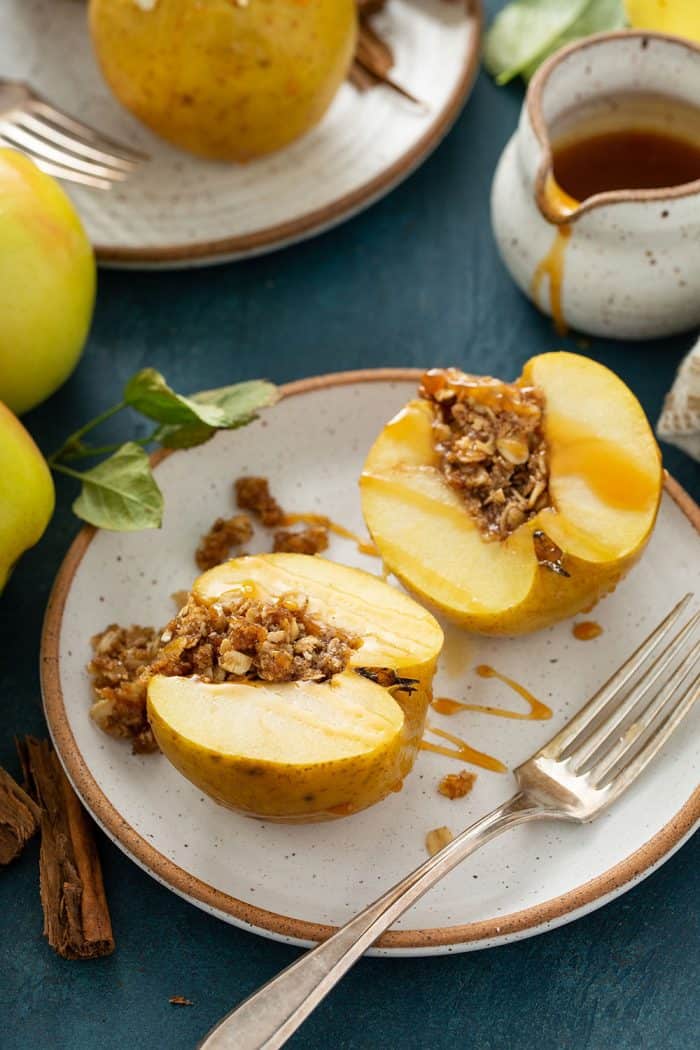 Plated baked apple cut in half to show the crumble filling