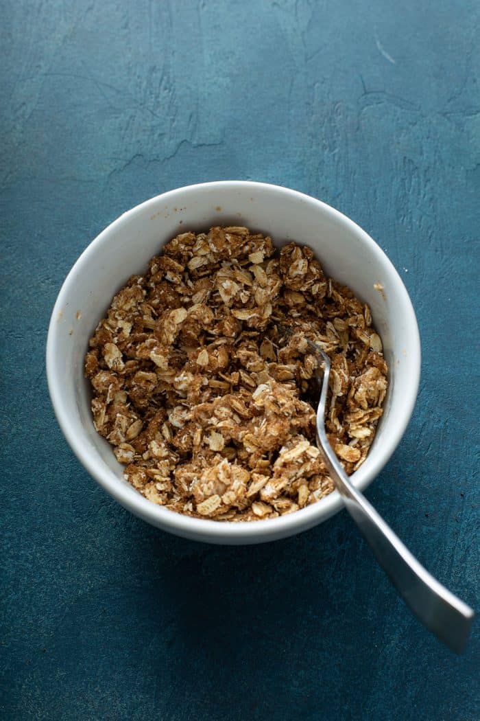 Oat crumble for baked apples in a white bowl